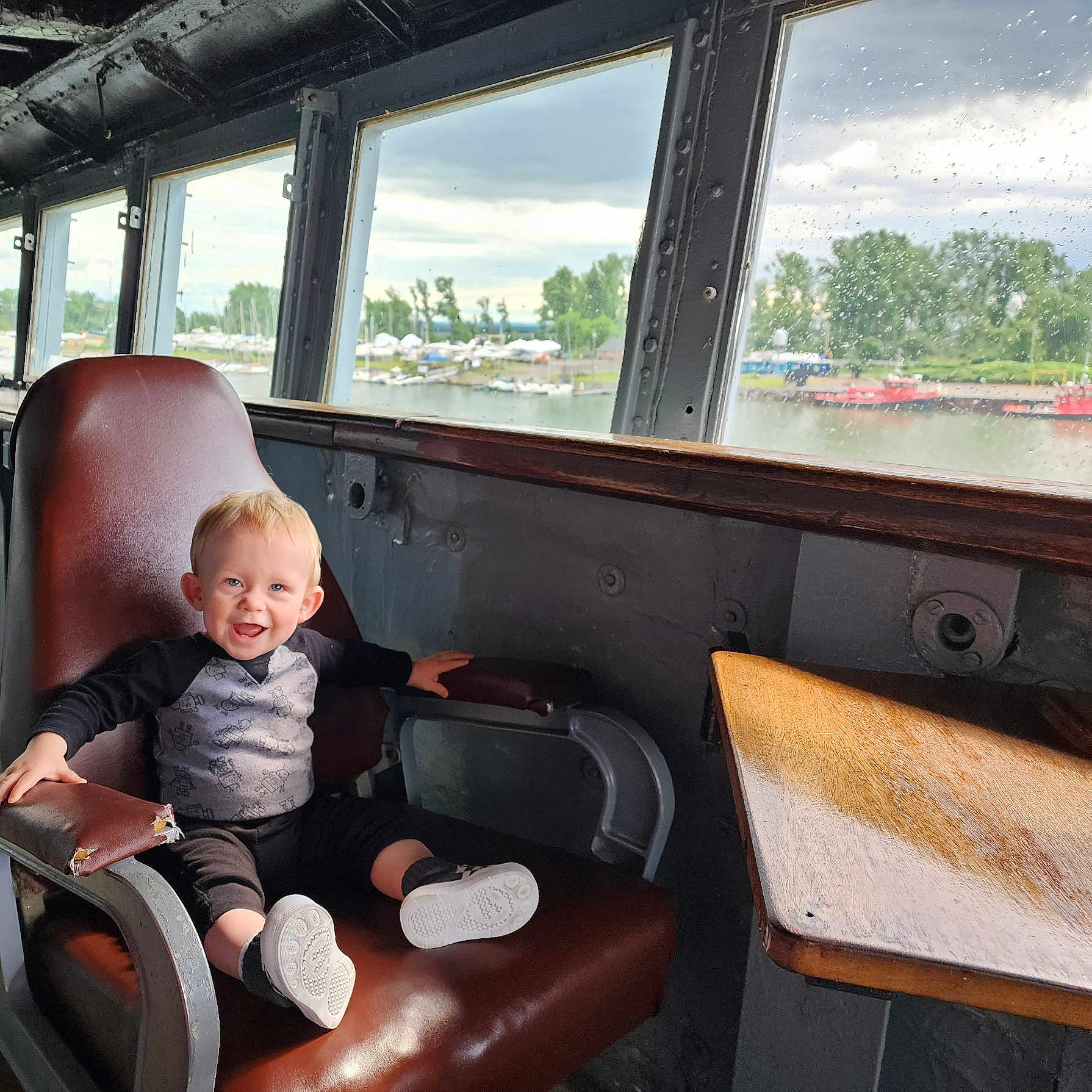Benjamin is registered to the contest to win money with this photo: architecture, boat, boy, building, chair, child, clothing, face, footwear, furniture, head, male, outdoors, person, photography, portrait, shelter, shoe, sitting, transportation