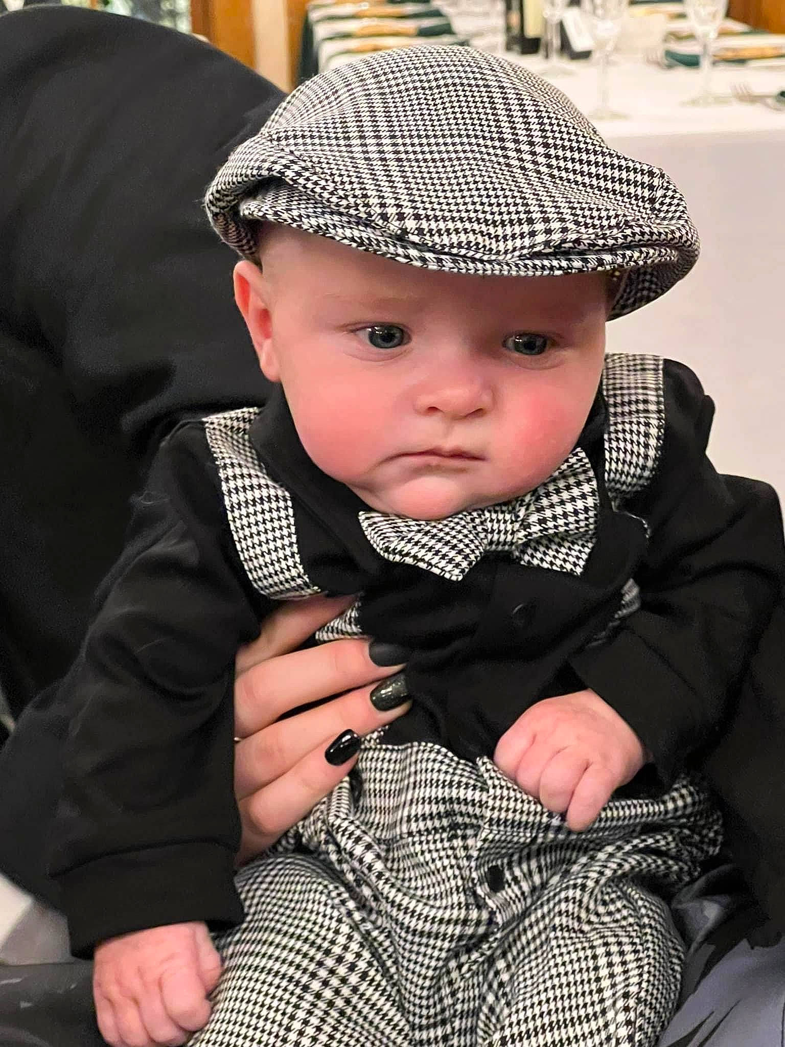 Everett is registered to the contest to win money with this photo: baby, baby_toddler_clothing, black, cap, cheek, child, collar, costume_hat, fashion_accessory, formal_wear, hat, headgear, headwear, pattern, person, photograph, sitting, skin, sleeve, sun_hat