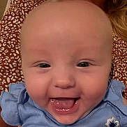 Serenity joined the competition — help win amazing prizes! baby, smiling, close_up, blue_clothing, flower_embroidery, person_holding, patterned_shirt, joyful, infant, face, mouth_open, happy, child, skin, head, eyes, cheeks, indoor, portrait, human