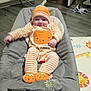 Karter is registered to the contest to win money with this photo: animal_mat, baby, baby_seat, child, cozy, cute, floor, footwear, gray_cushion, happy, hat, headwear, home, indoor, infant, person, pumpkin_outfit, smiling, striped_clothing, toy