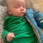 Karter is registered to the contest to win money with this photo: baby, bed, blanket, blue_jacket, child, cozy, cute, face, green_clothing, hand, indoors, infant, peaceful, pillow, portrait, resting, sleep, sleeping, soft_texture, young_child
