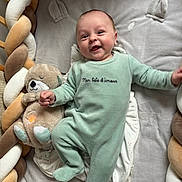 Léon a rejoint le concours — aidez-le/la à gagner de superbes lots ! baby, infant, smile, onesie, plush_toy, crib, braided_cushion, sleeping_bed, child, cute, happy, soft_toys, cozy, baby_clothes, indoor, person, portrait, resting, playful, newborn