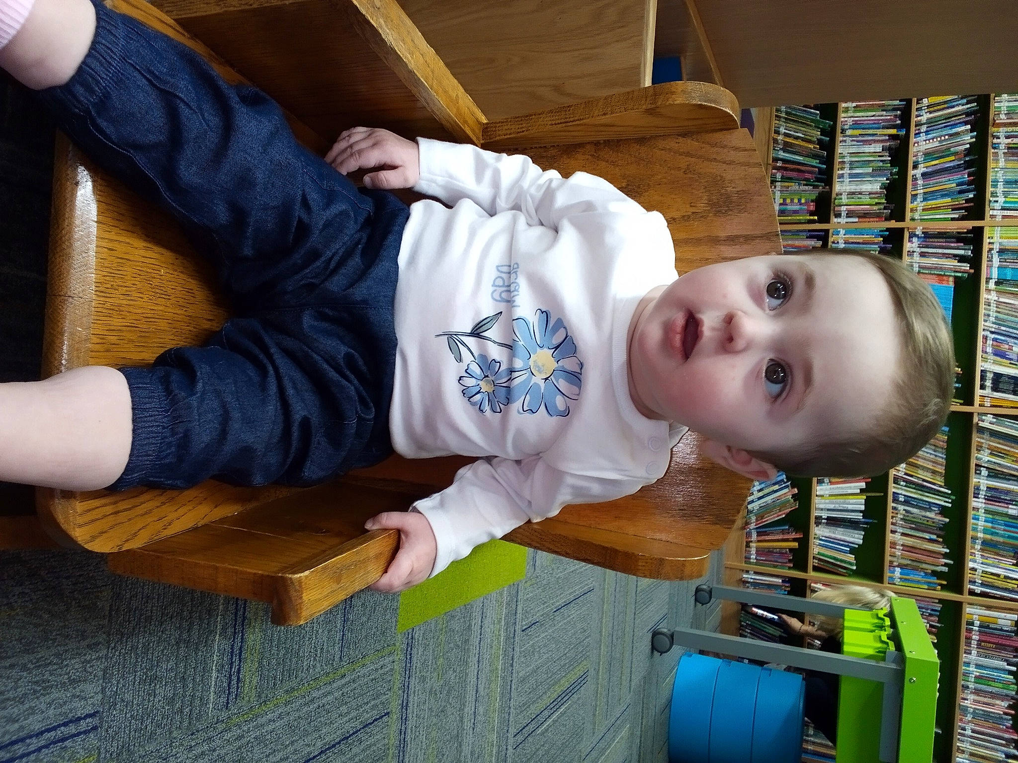 Pasiley is registered to the contest to win money with this photo: baby, baby_toddler_clothing, bookcase, child, comfort, elbow, electric_blue, fun, happy, person, product, publication, room, shelf, sitting, sleeve, smile, standing, toddler, wood