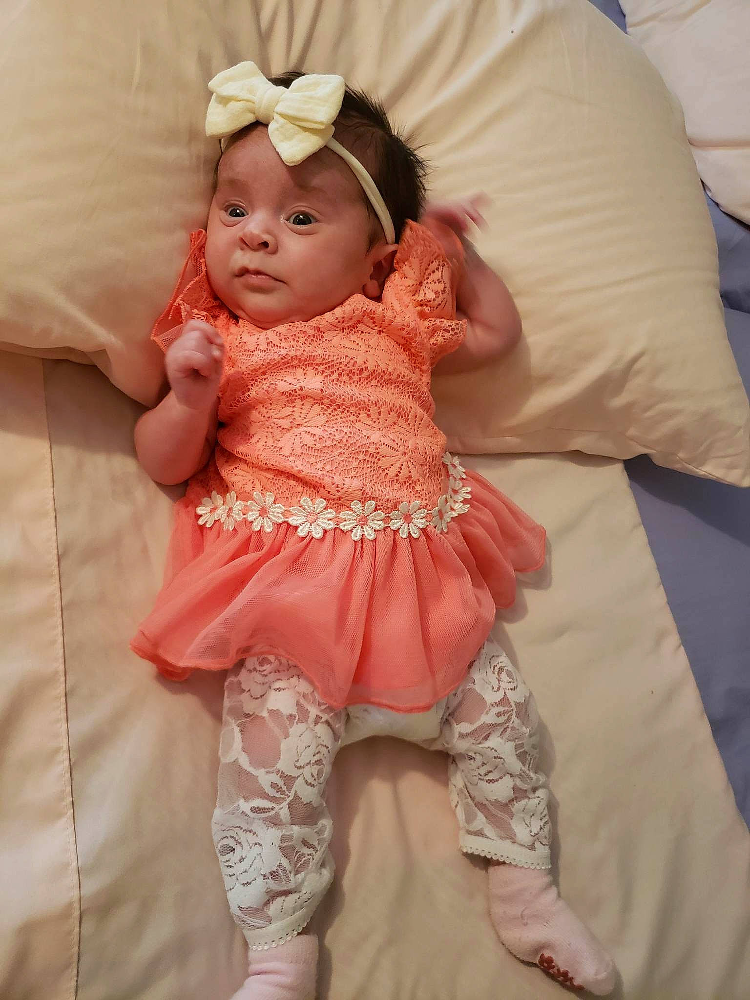 Toni is registered to the contest to win money with this photo: baby, baby_toddler_clothing, blond, cheek, doll, dress, embellishment, eye, face, head, headpiece, headwear, lip, orange, pattern, peach, person, pink, skin, sleeve