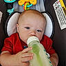 Brently joined the competition — help win amazing prizes! baby, bottle, milk, red_shirt, seat, toy, cushion, child, infant, feeding, hand, face, blue_eyes, warning_label, closeup, indoor, cute, relaxing, pacifier, plastic