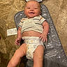 baby, infant, smiling, diaper, striped_shirt, changing_pad, floor, winnie_the_pooh, happy, cute, child, skin, person, lying_down, indoors, floor_tiles, baby_changing_station, playful, young_child, casual