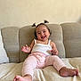baby, child, smiling, happy, pigtails, pink_pants, white_tank_top, couch, beige, indoor, person, cute, infant, small_hands, barefoot, plush, relaxed, portrait, sitting, home