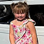 child, girl, pigtails, floral_dress, smiling, white_car, vintage_car, outdoor, daylight, people, event, classic_car, vehicle, portrait, happy, person, fashion, summer, casual, background