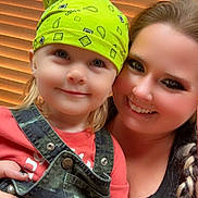 Rhiggs joined the competition — help win amazing prizes! child, woman, smile, bandana, green_bandana, overalls, camouflage, braid, makeup, portrait, indoor, window_blinds, holding, happy, person, fashion, casual_clothing, closeup, family, toddler