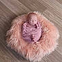 baby, newborn, sleeping, swaddle, pink, fluffy, fur_pouf, wood_floor, top_down, portrait, infant, cute, peaceful, prop, studio, soft_texture, hands, toes, wrapped, cozy