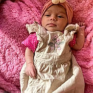 Joycelynn joined the competition — help win amazing prizes! baby, infant, pink_blanket, headband, flower, dress, strawberry_embroidery, lying_down, clothing, soft_texture, cute, child, portrait, indoor, young_child, hands, face, expression, skin, cozy