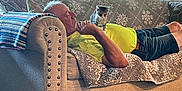 Pupadoodle is registered to the contest to win money with this photo: man, kitten, cat, couch, blanket, window, indoor, relaxing, furniture, patterned, yellow_shirt, shorts, resting, pet, home, daylight, curious, animal, elderly, comfort