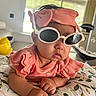 baby, infant, child, portrait, sunglasses, hat, pink_outfit, coral_clothing, ruffles, floral_cushion, lying_down, indoor, home, daylight, face, arms, hands, fashion, cute, photography