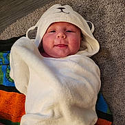 Finnian is registered to the contest to win money with this photo: baby, blanket, bonnet, cap, clothing, face, footwear, hat, head, hood, hoodie, knitwear, newborn, person, photography, portrait, shoe, sweater, sweatshirt, towel
