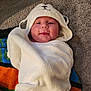 baby, blanket, bonnet, cap, clothing, face, footwear, hat, head, hood, hoodie, knitwear, newborn, person, photography, portrait, shoe, sweater, sweatshirt, towel