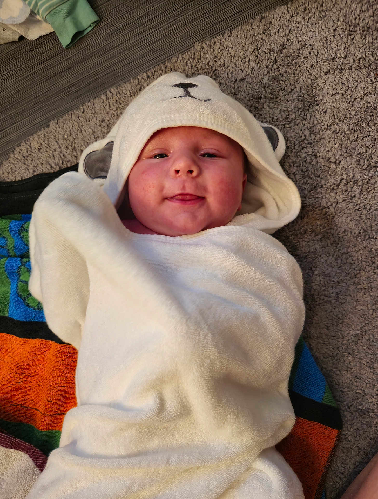 Finnian is registered to the contest to win money with this photo: baby, blanket, bonnet, cap, clothing, face, footwear, hat, head, hood, hoodie, knitwear, newborn, person, photography, portrait, shoe, sweater, sweatshirt, towel