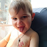André participe au concours pour gagner de l'argent avec cette photo : child, couch, eyes, face, hair, happy, indoor, jewelry, necklace, paint_marks, playful, portrait, real_person, shirtless, skin, smile, sunlight, toddler, tongue_out, window_light