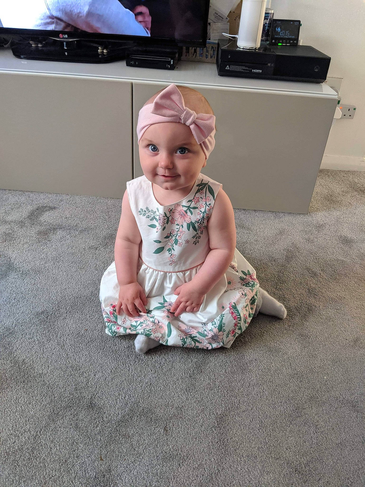 Aurora Rose is registered to the contest to win money with this photo: baby, child, dress, electronic_device, floor, flooring, fun, joy, leg, person, play, room, shoe, sitting, smile, technology, toddler, vacation