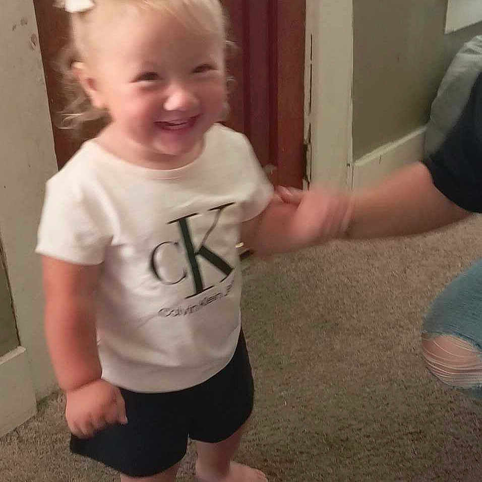 Paislee is registered to the contest to win money with this photo: baby, bodypart, city, clothing, door, face, happy, head, indoors, mouth, pants, person, photography, portrait, road, shorts, street, t_shirt, teeth, urban