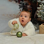 Lys participe au concours pour gagner de l'argent avec cette photo : baby, blanket, child, christmas, curious, cute, festive, frosted, gift_box, green_ball, holiday, holiday_decor, indoor, infant, ornament, pine_branches, portrait, smiling, white_coat, winter