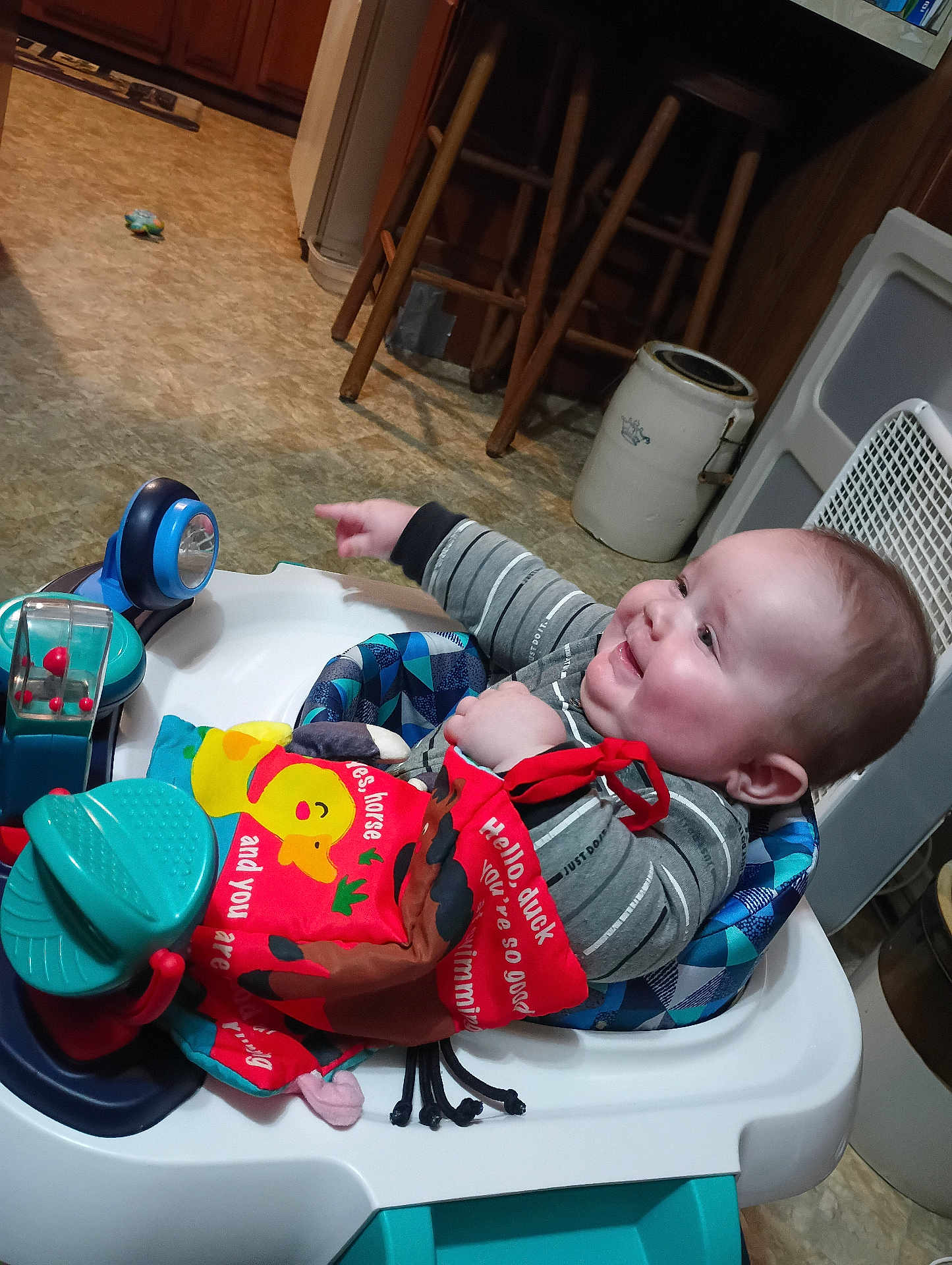 Braxton joined the competition — help win amazing prizes! baby, child, smiling, indoor, walker, toy, book, pointing, happy, person, clothing, floor, kitchen, cabinet, stool, seat, face, head, play, furniture