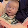 baby, infant, face, expression, cushion, pink, bunny_ears, clothing, striped_shirt, cartoon, indoor, child, person, cute, soft_toy, close_up, portrait, happy, newborn, comfort