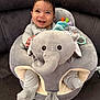 Jose is registered to the contest to win money with this photo: baby, smiling, child, plush_toy, elephant, seat, striped_clothing, happy, face, couch, indoor, comfort, soft_toy, infant, cute, sitting, cozy, joyful, portrait, young_child
