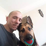 Mya participe au concours pour gagner de l'argent avec cette photo : animal, ball, black, brown, canine, casual_clothing, companion, dog, face, german_shepherd, home, indoor, man, person, pet, playing, selfie, short_hair, toy, wall