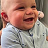 baby, child, infant, smiling, laughing, portrait, close_up, face, rosy_cheeks, blue_outfit, onesie, sitting, indoor, home, happy, joyful, short_sleeves, teeth, human, photography