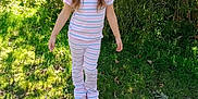 Kehlani joined the competition — help win amazing prizes! child, girl, outdoor, grass, sunlight, pajamas, striped_clothing, sneakers, greenery, bushes, daylight, nature, standing, casual, young, person, smile, hair_tied, playful, curious