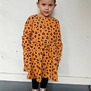 Kehlani is registered to the contest to win money with this photo: child, girl, leopard_print, dress, standing, boots, black_leggings, face, eyes, hair, ears, hands_in_pockets, floor, wall, indoor, portrait, smile, fashion, confident, young