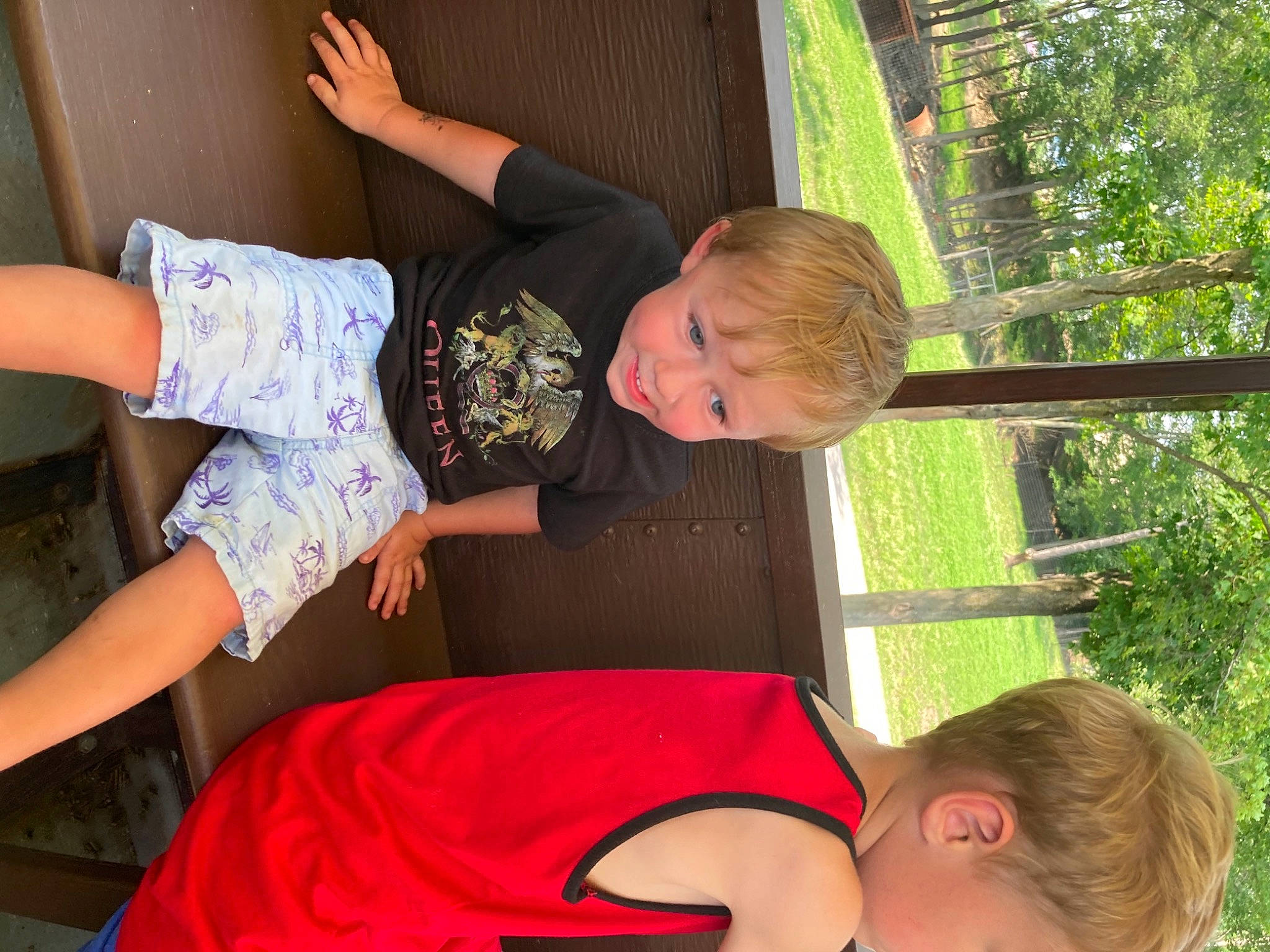 Lincoln is registered to the contest to win money with this photo: arm, child, fun, grass, green, hair, hairstyle, happy, human_body, joint, joy, leisure, organ, person, plant, red, summer, t_shirt, thigh, toddler