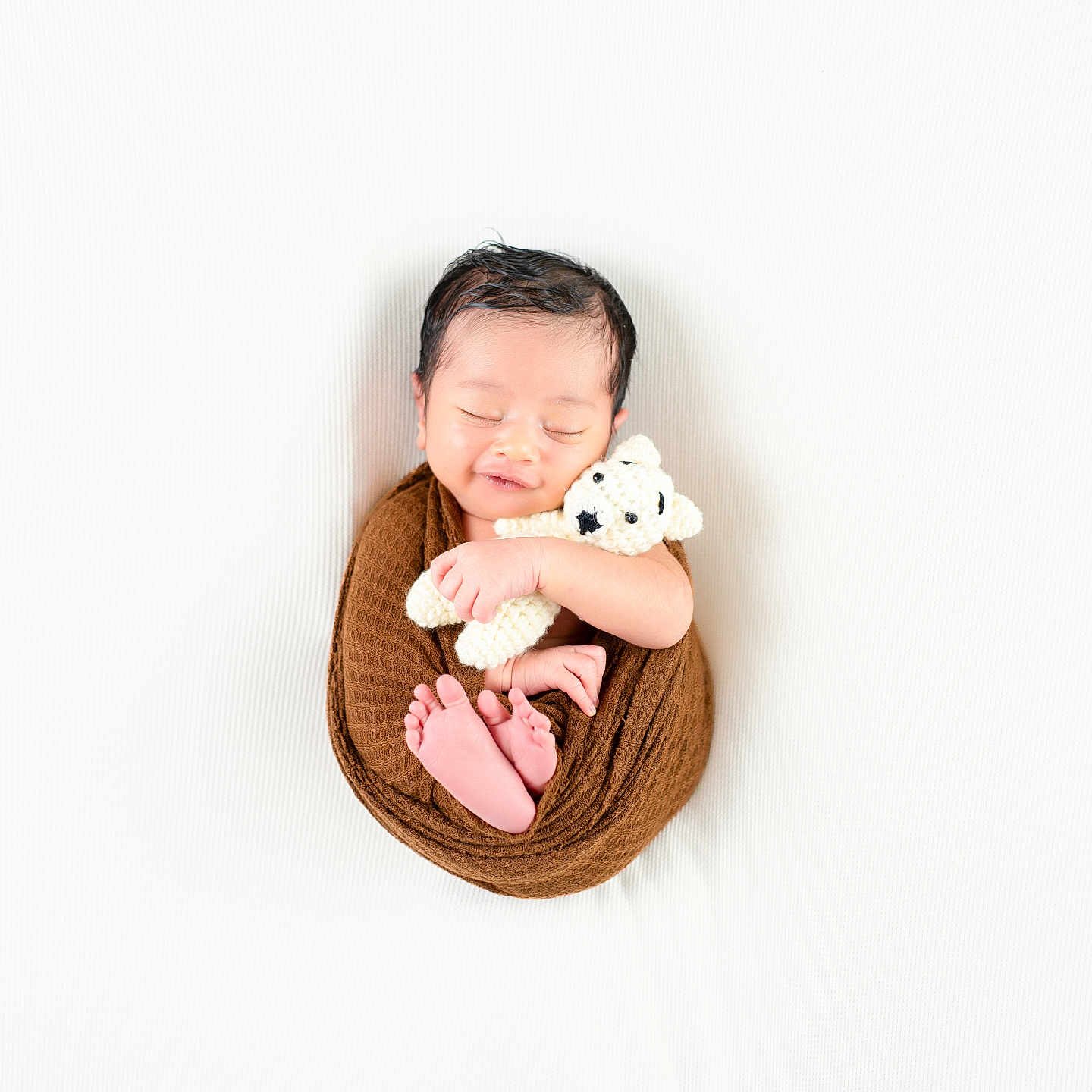 Akharvan joined the competition — help win amazing prizes! newborn, baby, sleeping, wrapped, brown_cloth, teddy_bear, crocheted_toy, soft_background, white, peaceful, smiling, cute, infant, portrait, tiny_feet, hands, cozy, serene, child, studio_photo