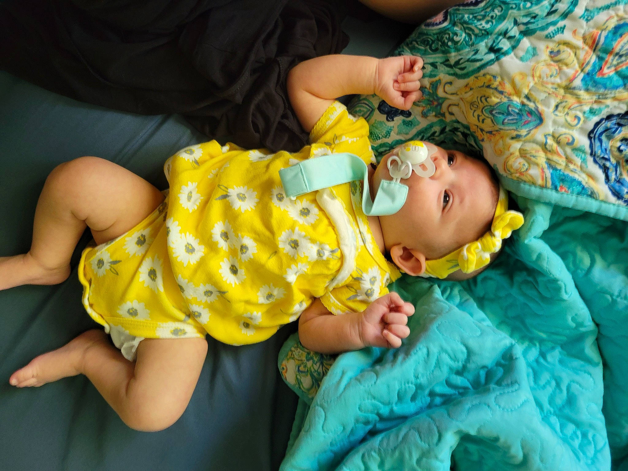 River Neihoff is registered to the contest to win money with this photo: arm, baby, baby_products, baby_toddler_clothing, child, comfort, dress, fun, grass, green, hand, happy, human_leg, pattern, person, sitting, skin, sleeve, t_shirt, thigh