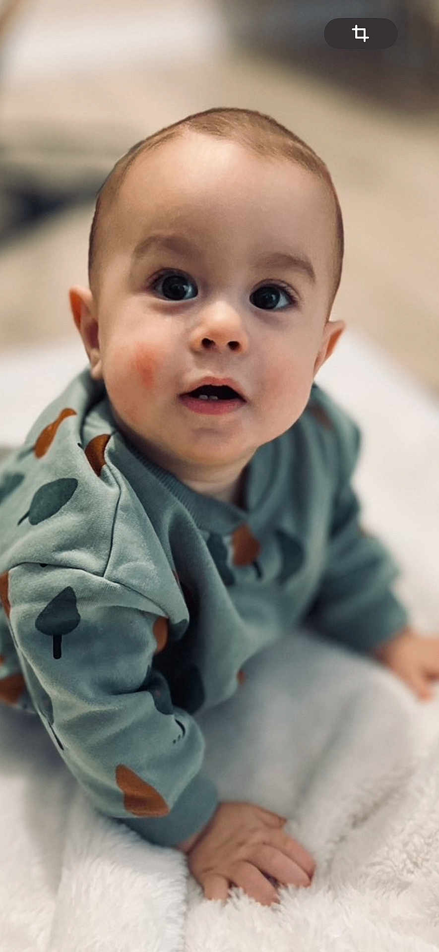 Kassim a rejoint le concours — aidez-le/la à gagner de superbes lots ! baby, child, infant, crawling, sweater, green_clothing, patterned_clothing, hand, face, wide_eyes, blanket, soft_texture, indoors, curious_expression, close_up, portrait, cute, young_child, head, skin