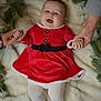 Luna joined the competition — help win amazing prizes! baby, child, red_dress, white_tights, smiling, lying_down, holding_hands, fur_blanket, greenery, holiday_theme, festive, happy, indoor, portrait, cute, people, celebration, hands, infant, cozy