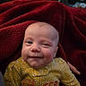 Kamiyah joined the competition — help win amazing prizes! baby, infant, face, smile, blanket, red_blanket, yellow_outfit, floral_pattern, clothing, child, person, indoors, cute, young, skin, head, expression, happy, cozy, portrait