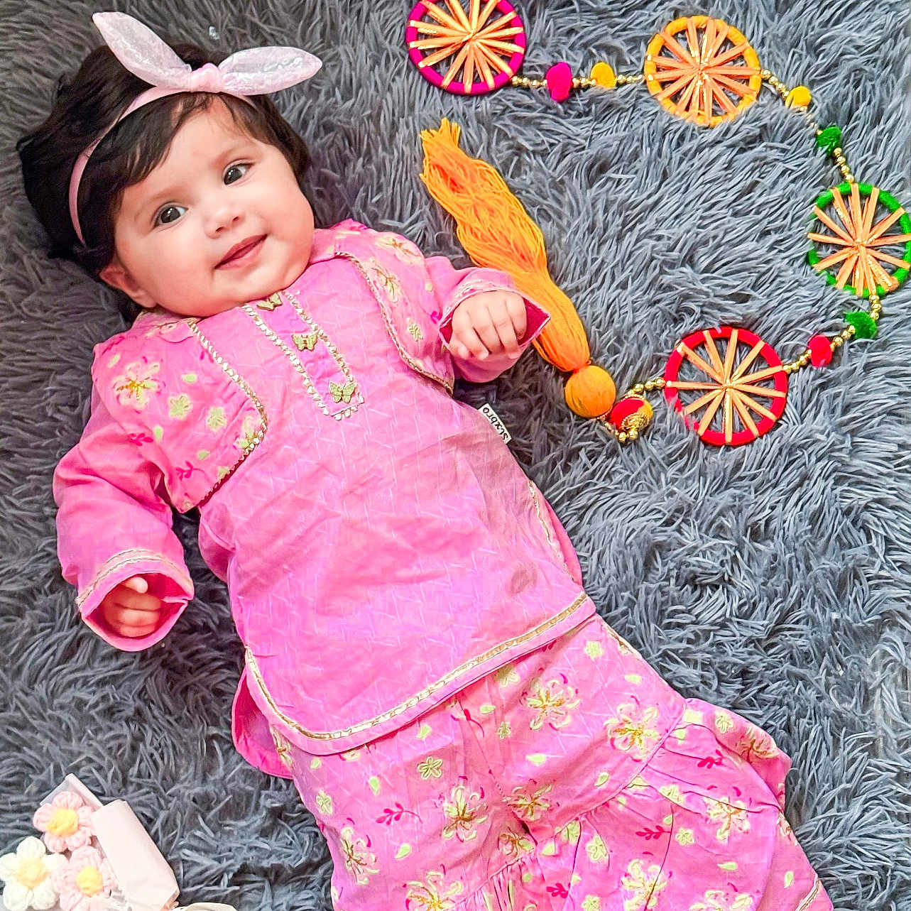 Ana joined the competition — help win amazing prizes! baby, bunny_ears, child, colorful, cute, decorative_circles, fabric_flowers, fashion, floral_pattern, gray_rug, happy, headband, indoors, lying_down, person, pink_outfit, playful, portrait, smiling, soft_texture