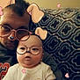 baby, infant, adult_male, selfie, filter_glasses, filter_dog_ears, hearts_overlay, sofa, patterned_blanket, couch, hoodie, onesie, portrait, close_up, indoors, living_room, face, cute, soft_lighting, family_moment