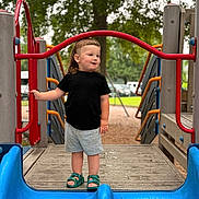 Bentley joined the competition — help win amazing prizes! black_shirt, blue_slide, child, daytime, gray_shorts, green_sandals, happy, leisure, outdoor, park, person, play, playground, red_railing, slide, smiling, summer, toddler, trees, wooden_platform