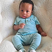 Scottie joined the competition — help win amazing prizes! baby, infant, child, blue_clothing, socks, blanket, soft_texture, cute, portrait, seated, indoors, curious_expression, cozy, comfortable, young_child, human, skin, face, hand, feet