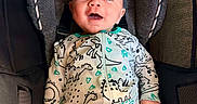 Spencer is registered to the contest to win money with this photo: baby, child, infant, smiling, happy, blue_eyes, portrait, car_seat, buckled, seated, indoor, close_up, dinosaur, printed_clothing, onesie, automobile, travel, face, head, photography