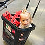 toddler, child, shopping_basket, blanket, indoor, floor, curious, plastic, red, black, hair_ties, portrait, person, cute, small, looking_up, expression, baby, toy_cart, flooring
