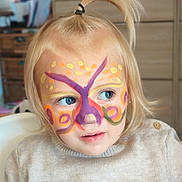 Love participe au concours pour gagner de l'argent avec cette photo : child, toddler, face_paint, butterfly, blue_eyes, blonde_hair, ponytail, sweater, indoor, curious, portrait, colorful, cute, person, closeup, face, expression, soft_light, furniture, cozy