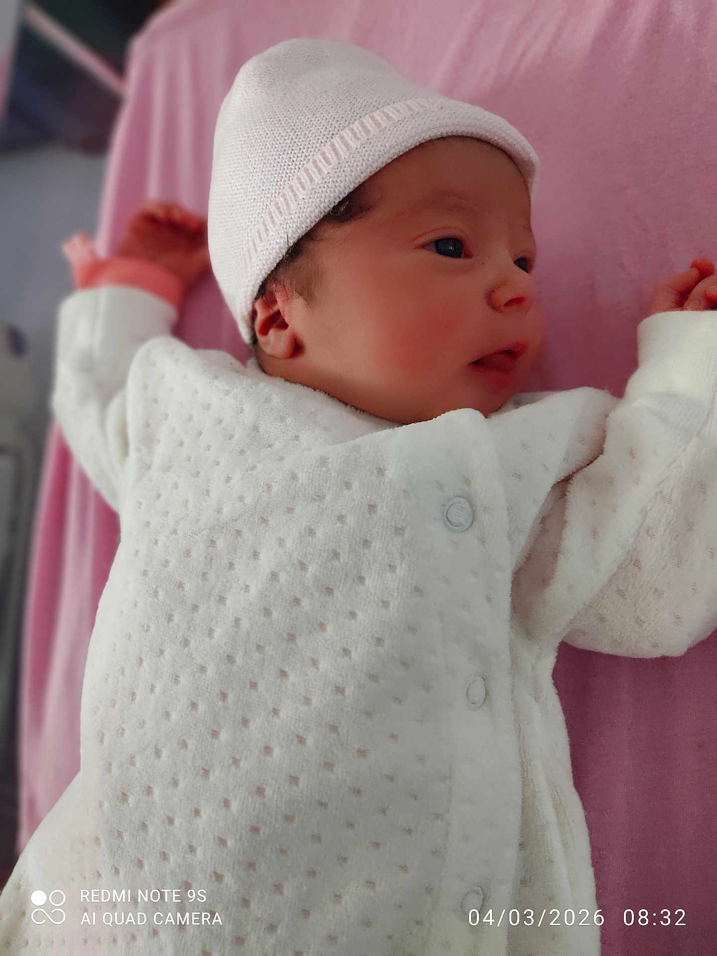 Hina a rejoint le concours — aidez-le/la à gagner de superbes lots ! baby, newborn, infant, hat, knit_hat, onesie, white_clothing, pink_blanket, bed, face, portrait, closeup, sleeping, hand, button, soft_texture, crib, timestamp, watermark, cozy