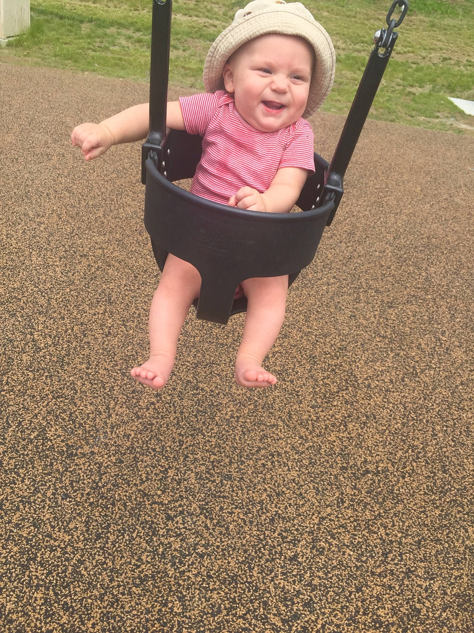 Grayson is registered to the contest to win money with this photo: barefoot, child, city, fun, grass, human_settlement, leisure, outdoor_play_equipment, person, play, playground, public_space, recreation, sand, smile, swing, toddler, vacation