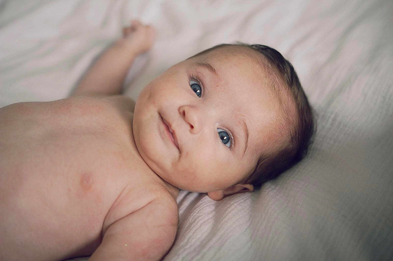 Gaby participe au concours pour gagner de l'argent avec cette photo : baby, infant, skin, blue_eyes, lying_down, blanket, cute, face, portrait, newborn, child, soft_lighting, smile, young, human, indoors, closeup, head, expression, peaceful