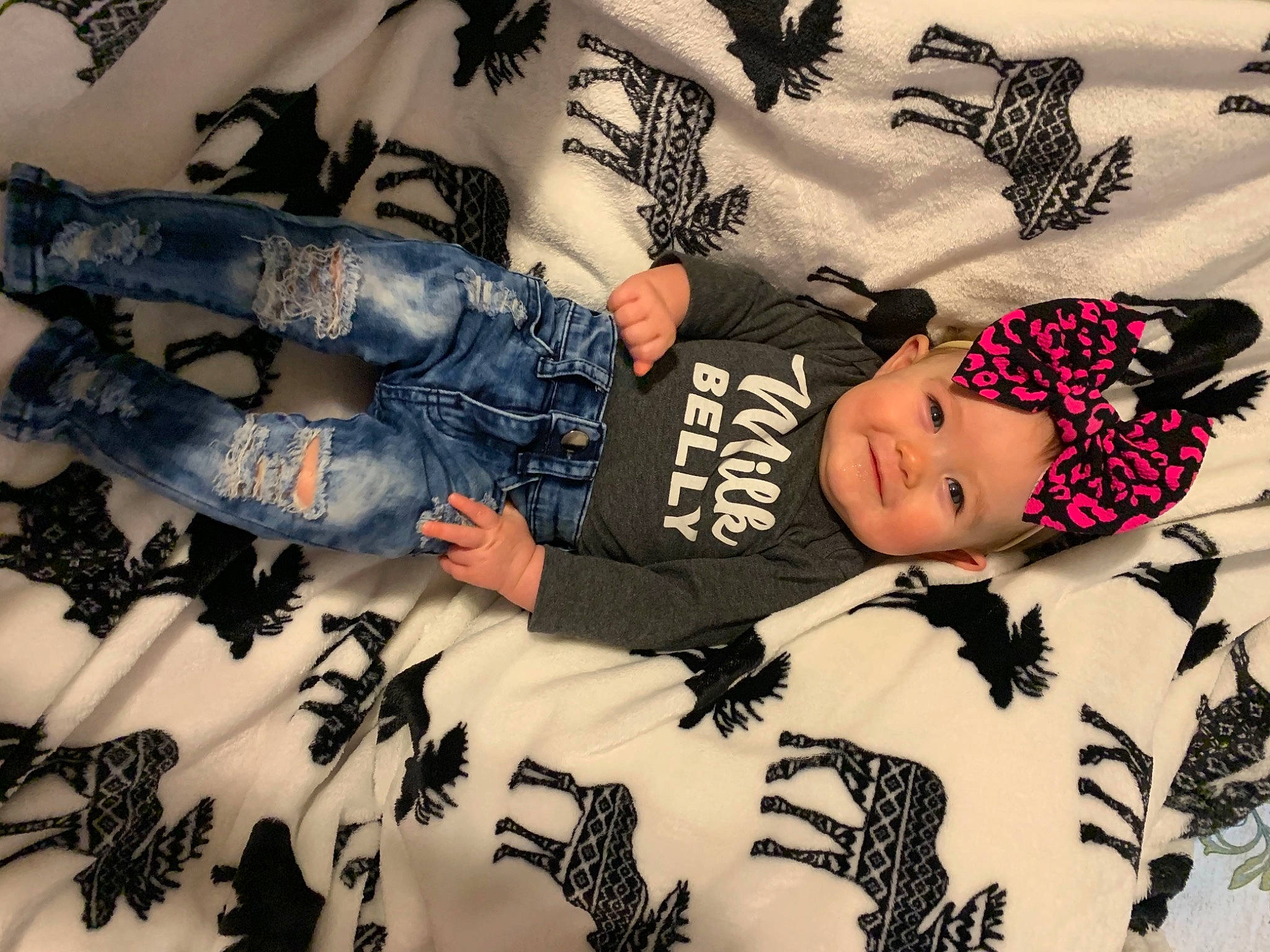Johnna is registered to the contest to win money with this photo: arm, baby, baby_toddler_clothing, black, child, comfort, fashion, fashion_design, gesture, headwear, joy, linens, pattern, people, person, room, sleeve, t_shirt, textile, thigh