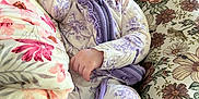 Lainey is registered to the contest to win money with this photo: baby, sleeping, infant, onesie, floral_pattern, cushion, blanket, indoor, peaceful, soft_lighting, closeup, cute, child, person, relaxing, home, portrait, newborn, resting, cozy
