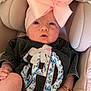 baby, infant, car_seat, pink_bow, headband, bracelet, clothing, seatbelt, fabric, cute, portrait, child, sitting, closeup, face, skin, apparel, comfort, indoor, accessory